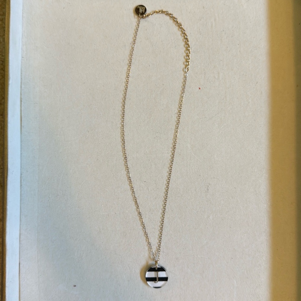 Woman’s initial J necklace.